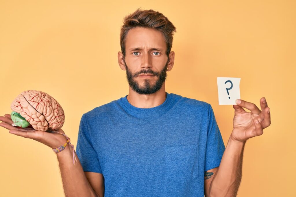Homme tenant un cerveau illustrant la question de la manipulation en PNL